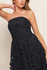 Black woven lace midi dress with straight neckline, ruffled hemline, and back zipper closure