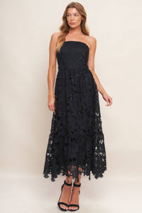 Black woven lace midi dress with straight neckline, ruffled hemline, and back zipper closure