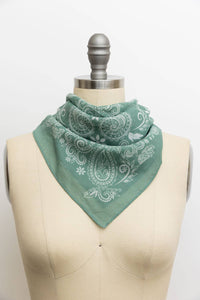 Sage green paisley print bandana tied around a dress form mannequin, featuring a tonal white floral and teardrop paisley pattern