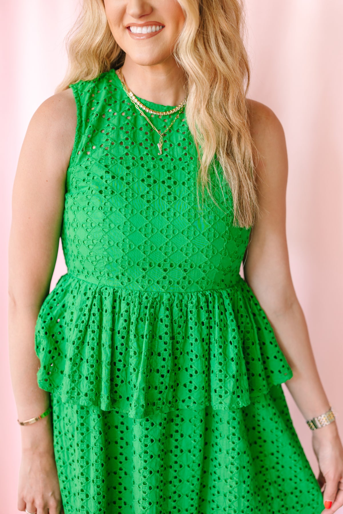 Close-up of fitted bodice and crew neckline on a bright green eyelet sleeveless midi dress with double tiered ruffle skirt detail