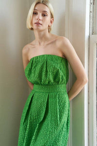 Textured woven green midi dress with strapless neckline, inverted pleats, straight skirt, back slit, and side zipper