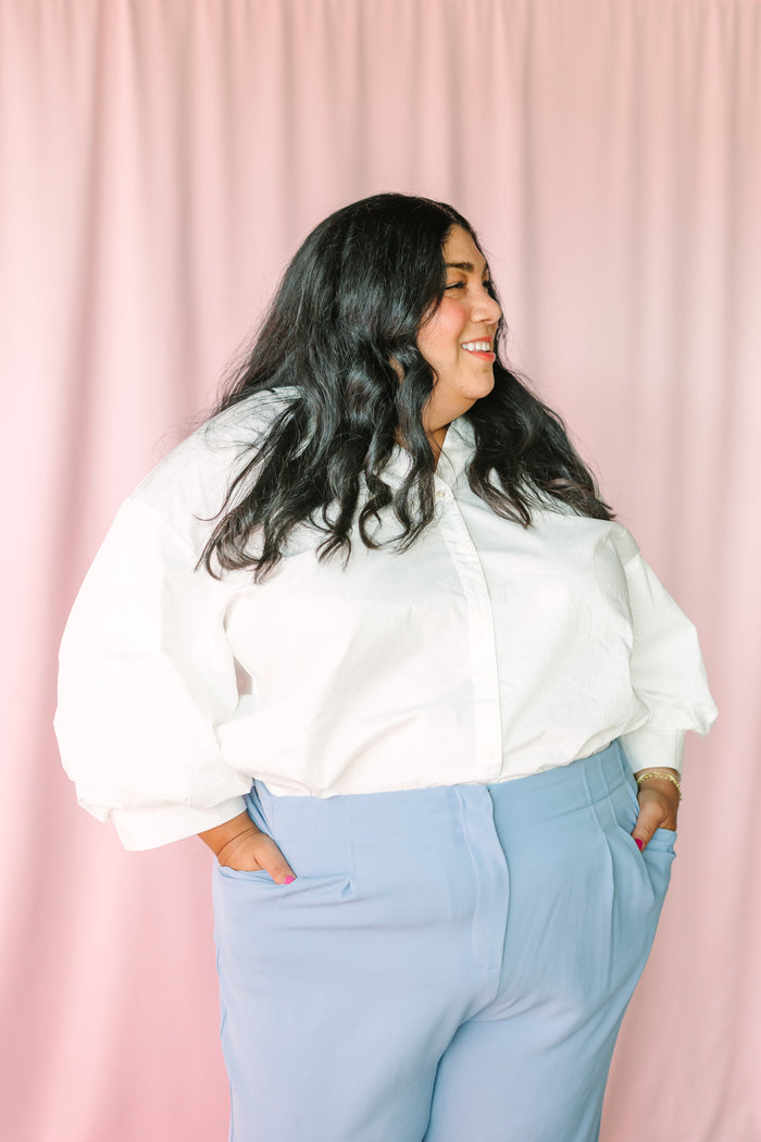 Detail view of white cotton poplin button-down top showing relaxed silhouette 
