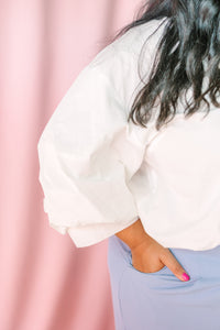 Close-up of voluminous puff sleeve on white poplin button-down top
