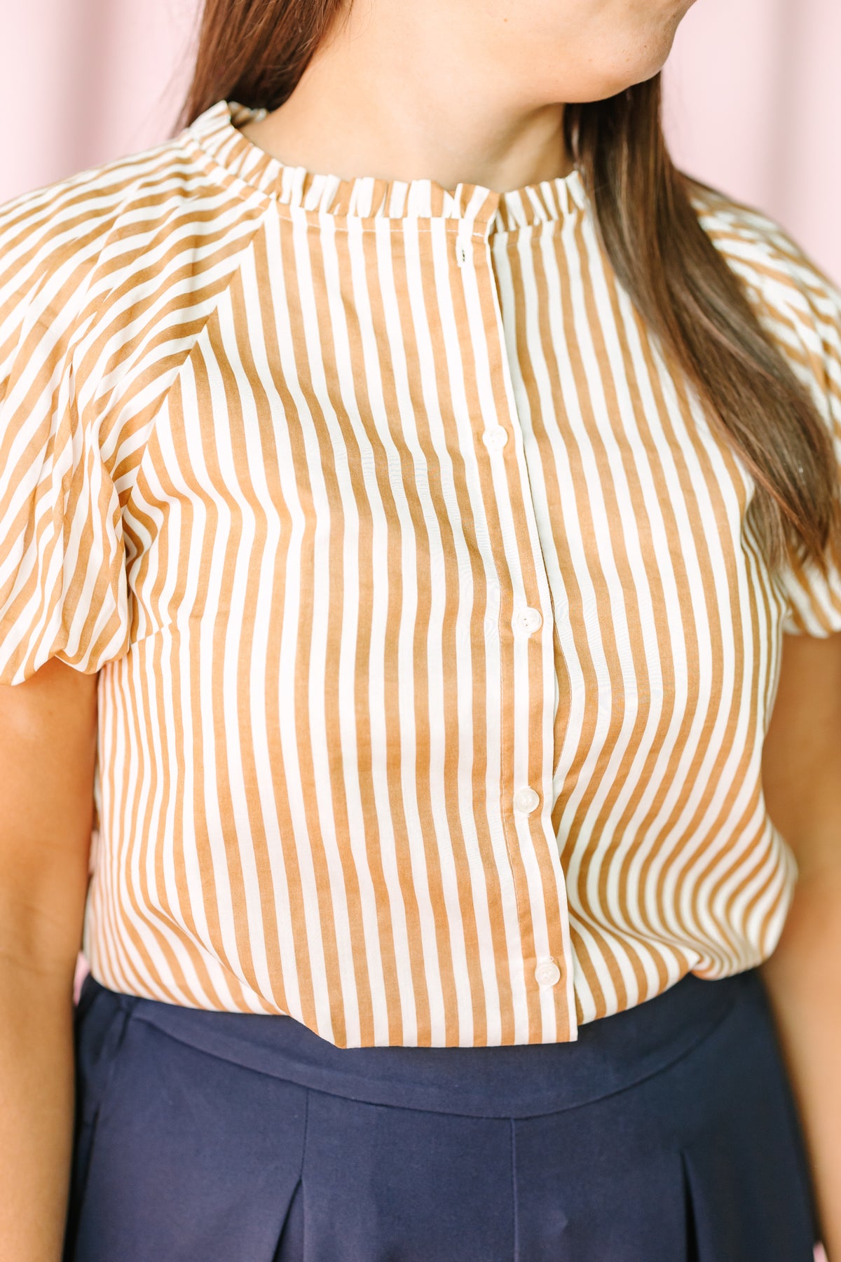 Tan and white striped puff sleeve blouse with button front placket and ruffle mock neck detail