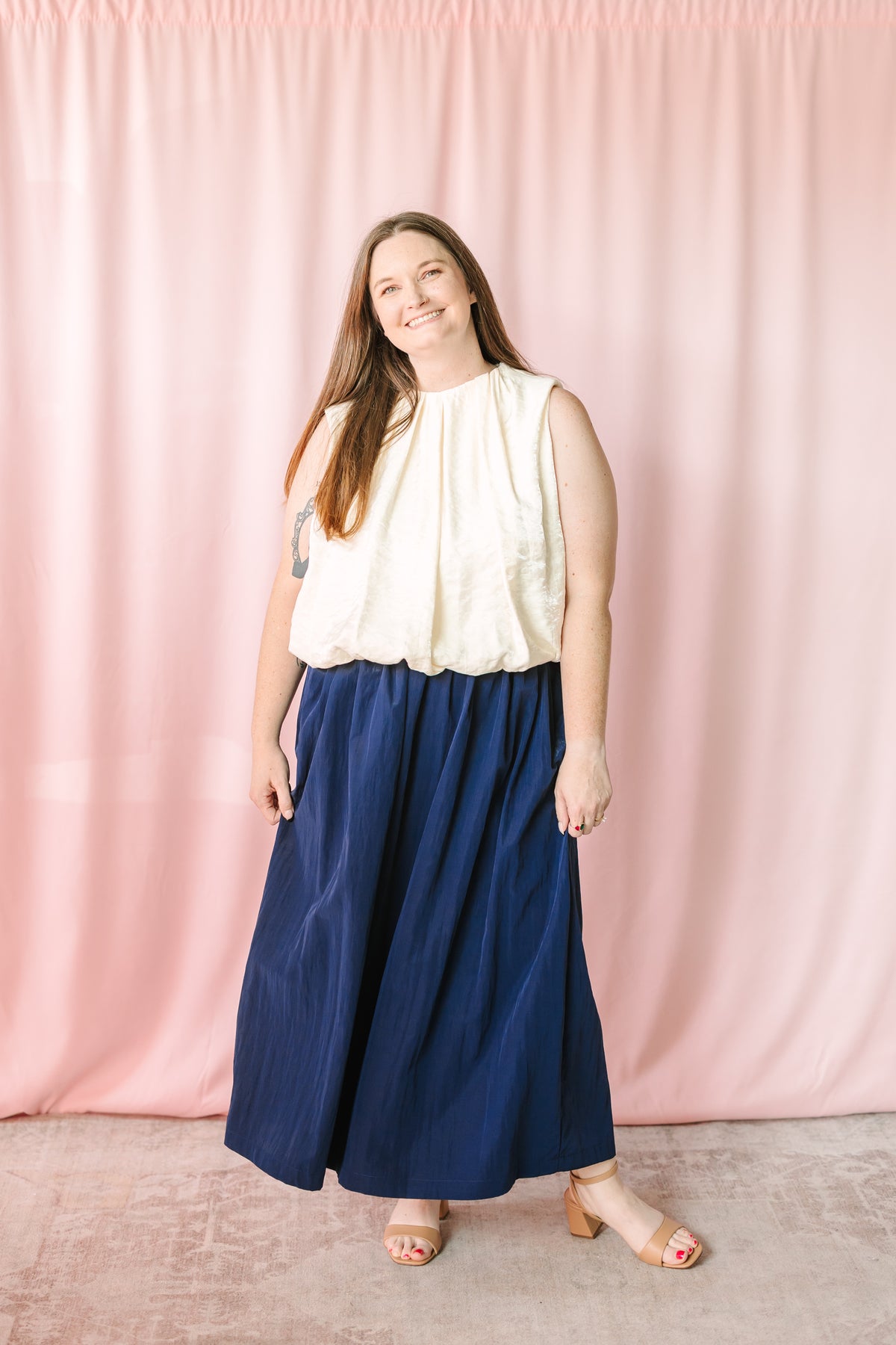 Navy blue gathered maxi skirt styled with cream sleeveless bubble hem top and nude block heel sandals