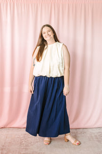 Navy blue gathered maxi skirt styled with cream sleeveless bubble hem top and nude block heel sandals