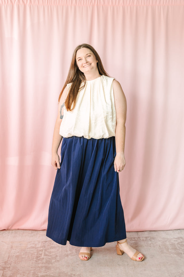 Navy blue gathered maxi skirt styled with cream sleeveless bubble hem top and nude block heel sandals