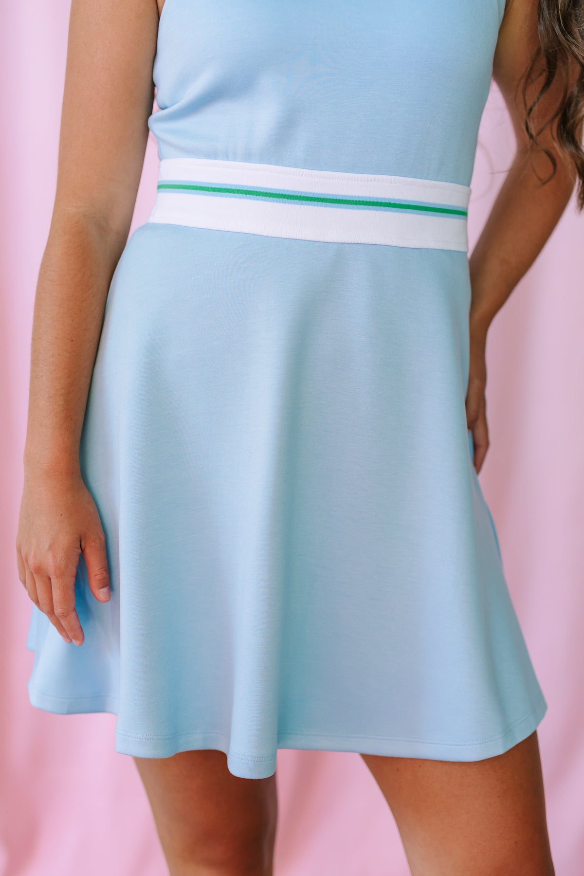 Close-up of a light blue fit-and-flare dress showing the white and green stripe elastic waistband and flared skirt