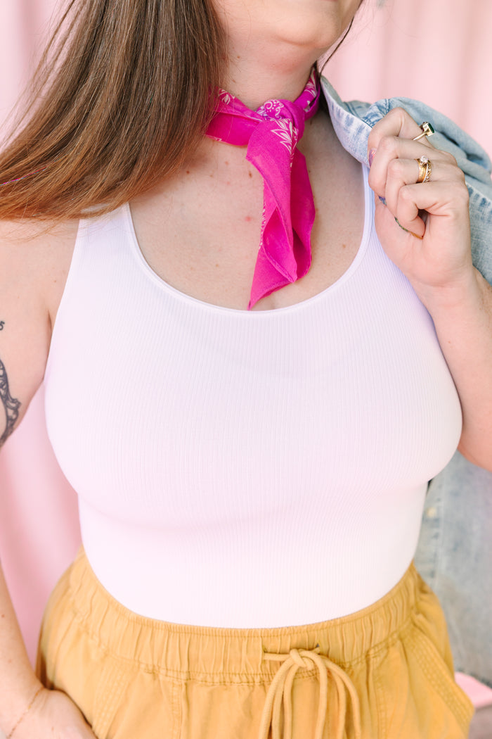 Close-up of a white seamless ribbed tank top styled with a pink bandana scarf and yellow drawstring pants