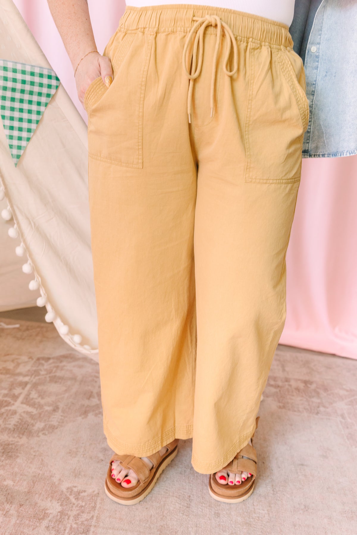 golden yellow wide-leg pants with drawstring waist and patch pockets, paired with tan platform sandals