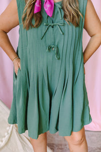 Detail view of sage green pleated sleeveless romper showing double tie front closure and flowy pleated skirt"