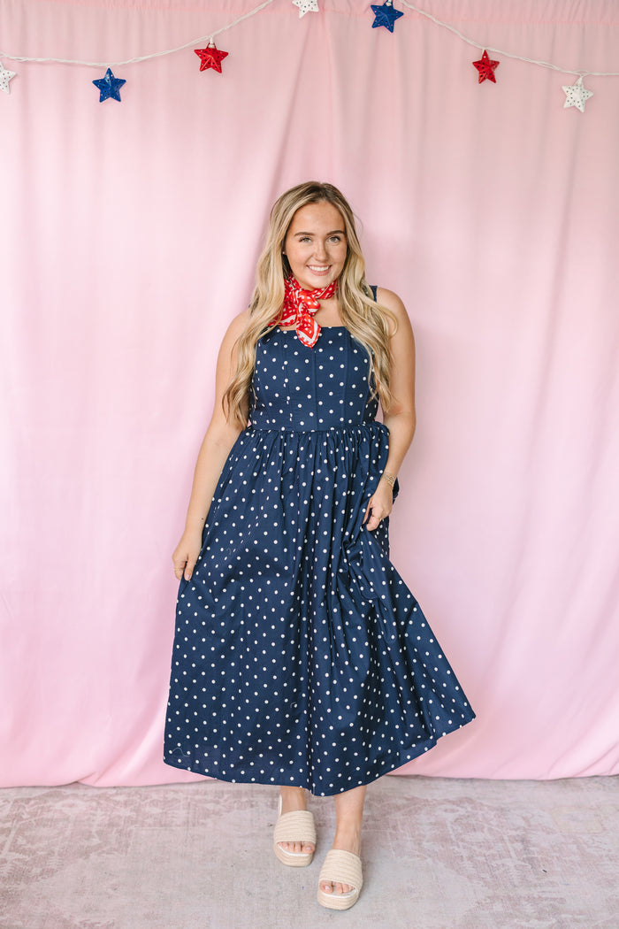 Navy polka dot midi dress with white dots, front view, worn by model