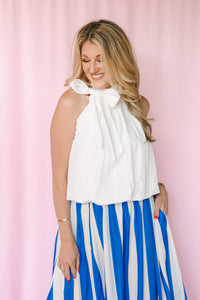 Close-up of tie-wrap detail on white sleeveless bubble hem top