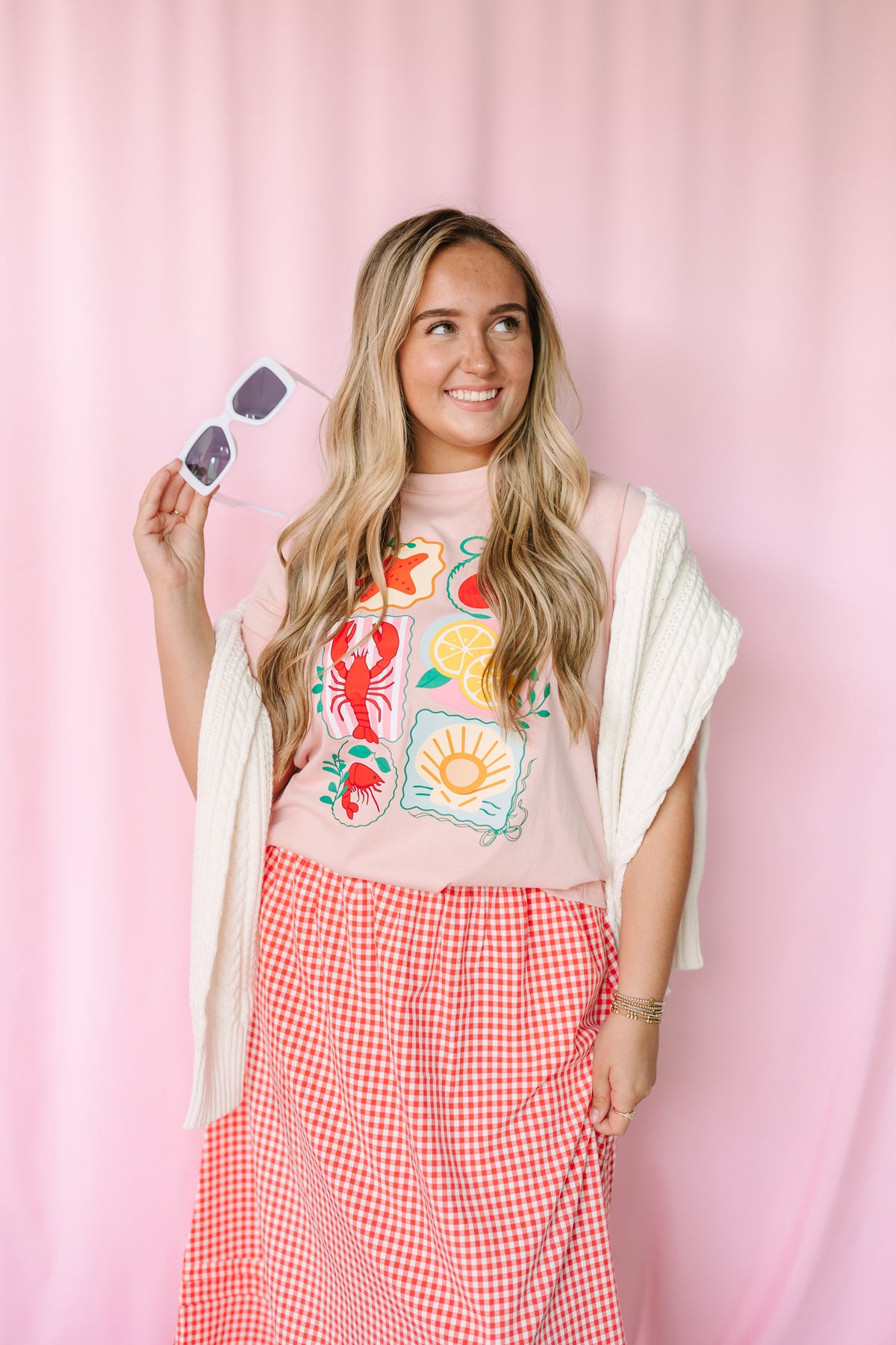 Women's pink nautical graphic tee, styled view with beach-inspired design