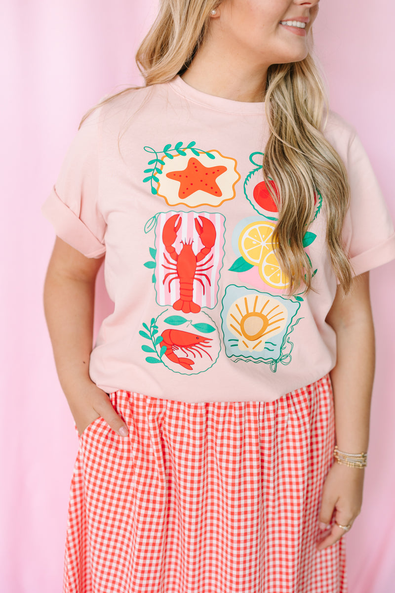Women's pink nautical graphic tee, styled view with beach-inspired design