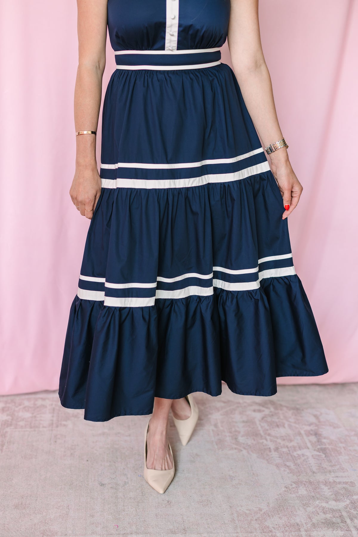 Detail view of navy tiered maxi dress skirt with double white stripe trim at each tier ruffle