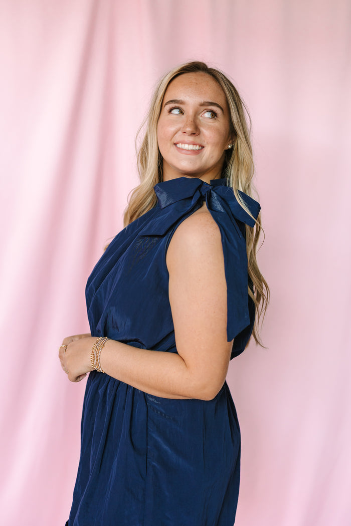 Close-up of navy halter romper bow tie neckline detail
