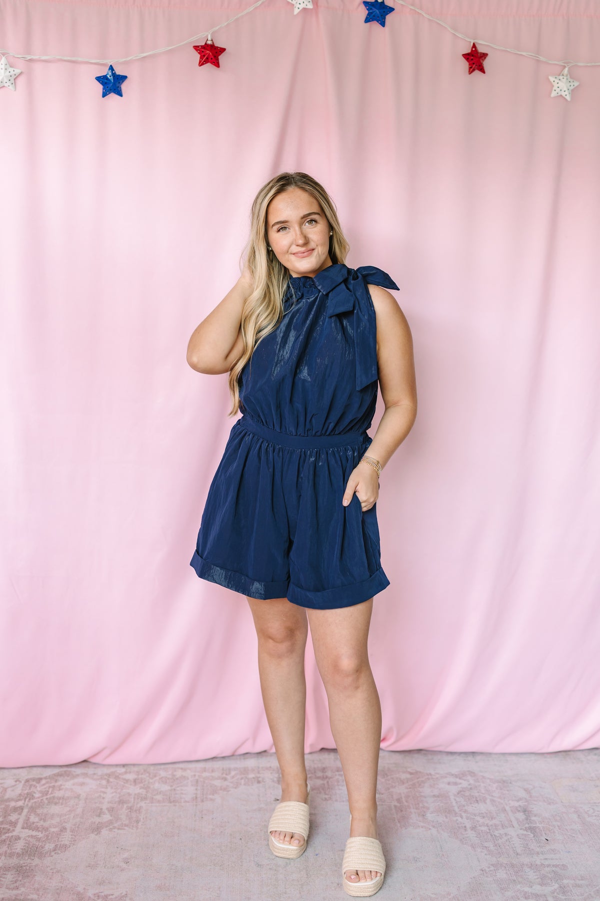 Navy bow tie halter romper with elasticized waist and shorts – front view on model