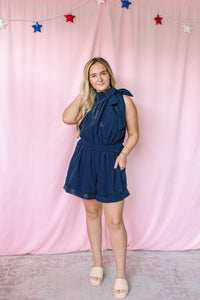 Navy bow tie halter romper with elasticized waist and shorts – front view on model
