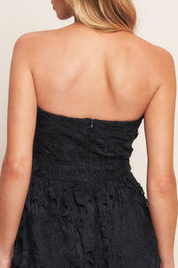 Black woven lace midi dress with straight neckline, ruffled hemline, and back zipper closure