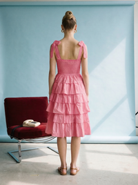 Fuchsia tiered ruffle midi dress with smocked bodice, adjustable tie straps, and lightweight cotton fabric