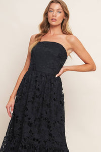 Black woven lace midi dress with straight neckline, ruffled hemline, and back zipper closure